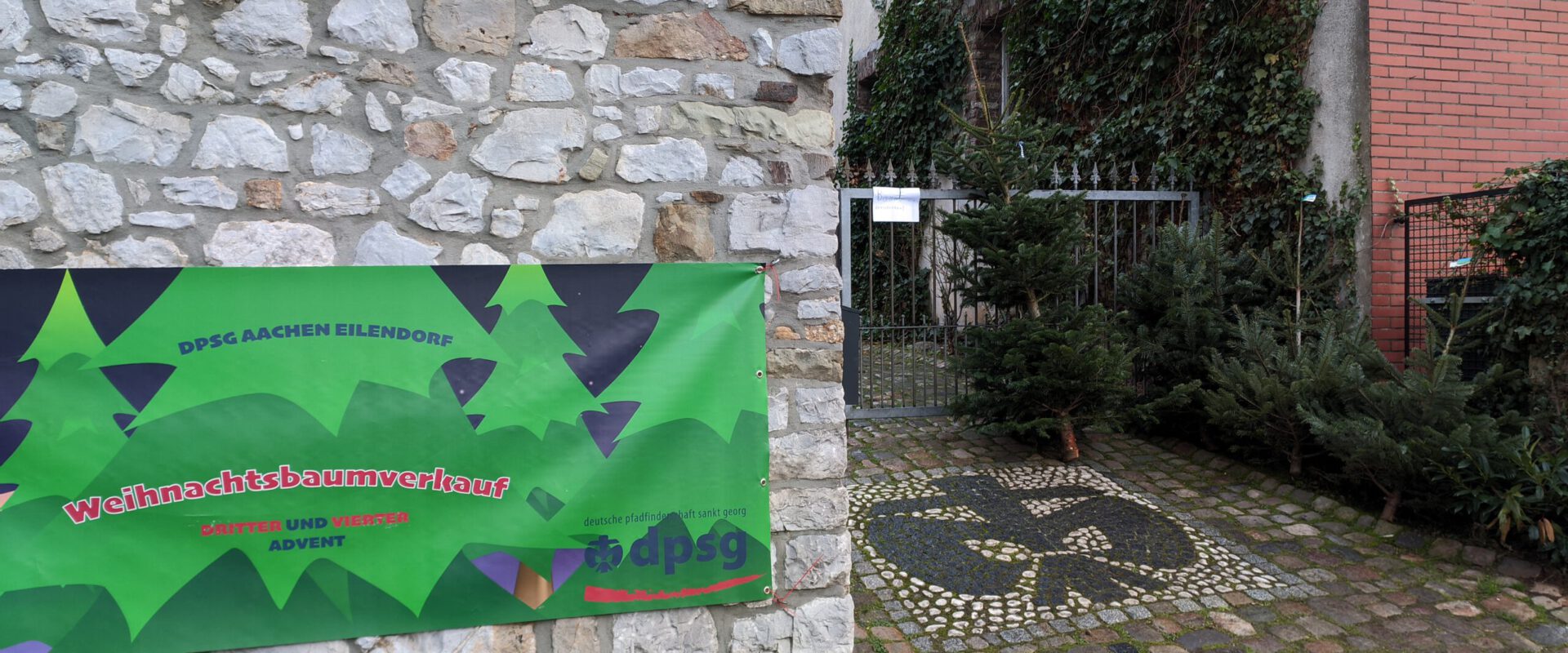 Die restlichen Weihnachtsbäume stehen neben einem Plakat mit der Aufschrift 