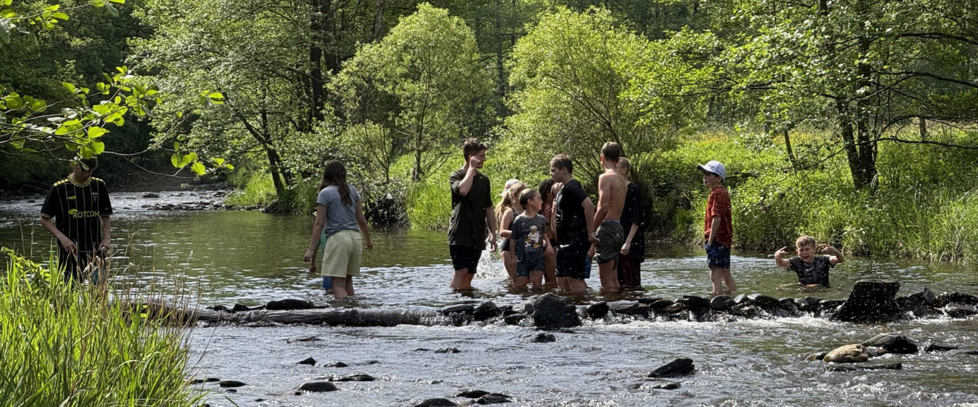 Pfingstlager 2026 3 Gruppenkinder stehen im gestauten Fluss auf dem Pfingstlager